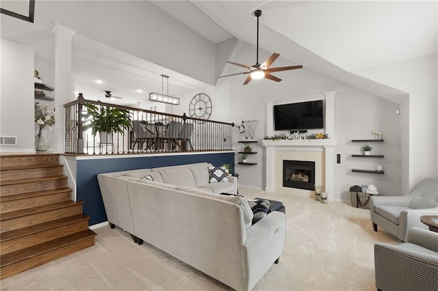 carpeted living room with stairs, a fireplace, high vaulted ceiling, and a ceiling fan