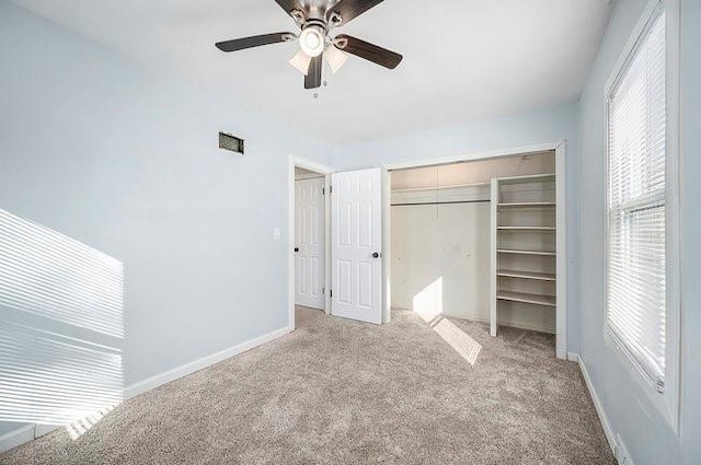 unfurnished bedroom with visible vents, baseboards, a ceiling fan, light colored carpet, and a closet