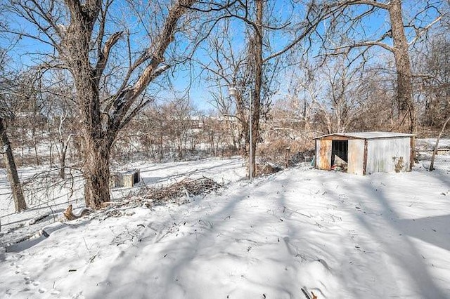 snowy yard with an outbuilding and a storage unit