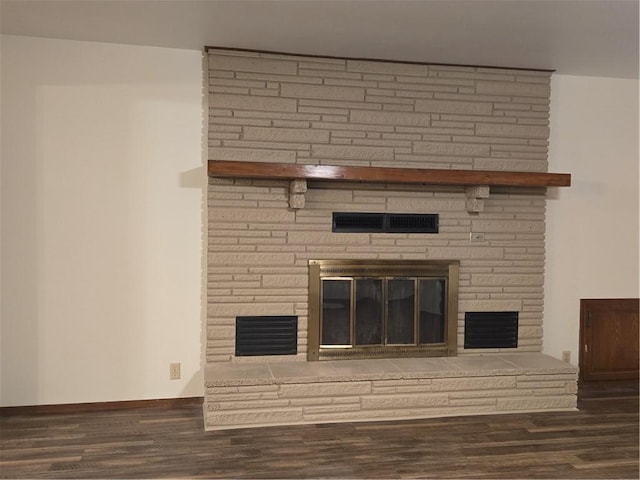 room details featuring a stone fireplace, wood finished floors, visible vents, and baseboards