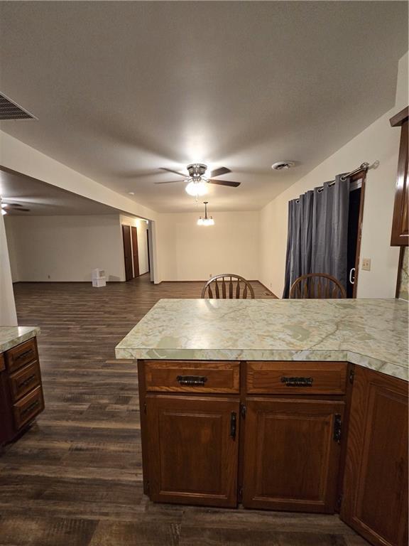 kitchen featuring visible vents, dark wood-style floors, ceiling fan, open floor plan, and light countertops