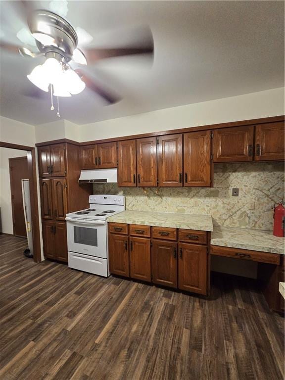 kitchen with white electric stove, light countertops, dark wood-type flooring, and under cabinet range hood