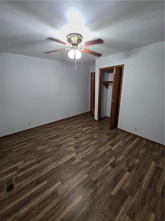 spare room with dark wood-style floors, visible vents, and ceiling fan