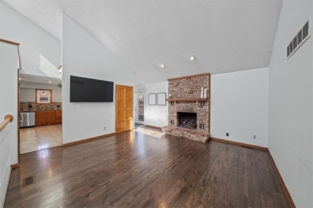 unfurnished living room featuring a fireplace, visible vents, and wood finished floors