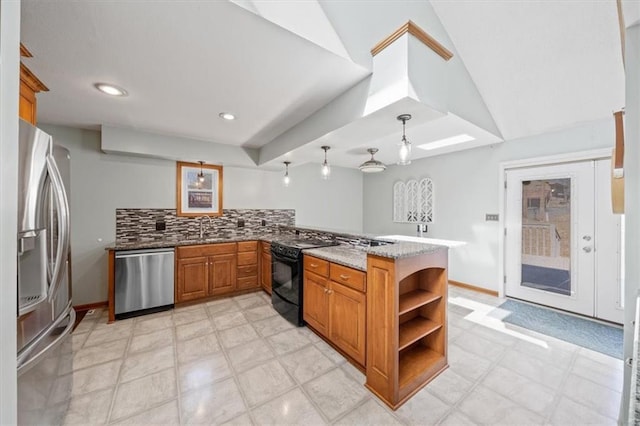 kitchen with light stone counters, brown cabinets, appliances with stainless steel finishes, a sink, and a peninsula