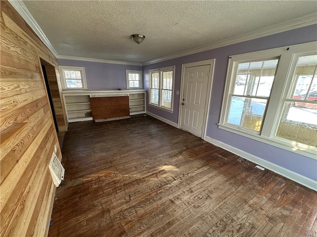 interior space featuring baseboards, a textured ceiling, ornamental molding, and dark wood-style flooring