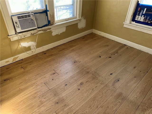 room details featuring cooling unit, baseboards, and wood finished floors