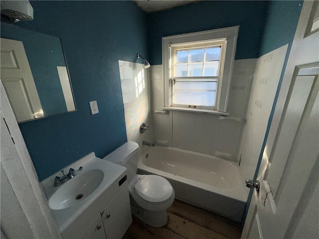 bathroom featuring washtub / shower combination, vanity, toilet, and wood finished floors