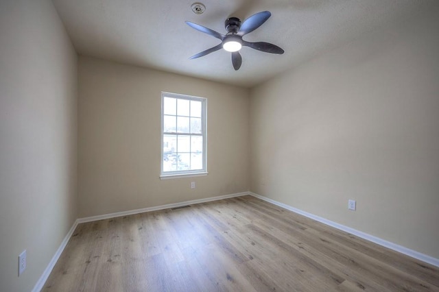 unfurnished room featuring light wood-type flooring, ceiling fan, visible vents, and baseboards