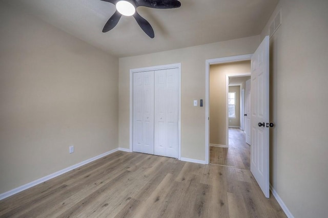 unfurnished bedroom with a ceiling fan, visible vents, baseboards, a closet, and light wood-type flooring