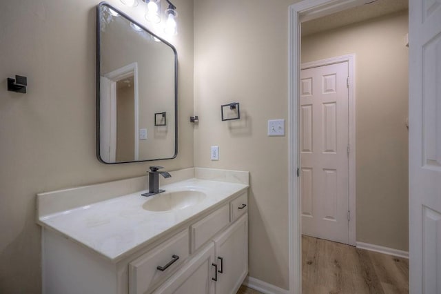 bathroom with vanity, baseboards, and wood finished floors