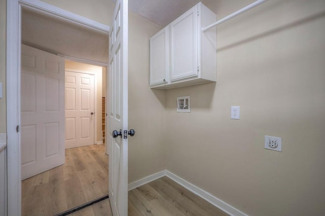 clothes washing area featuring washer hookup, light wood finished floors, cabinet space, hookup for an electric dryer, and baseboards