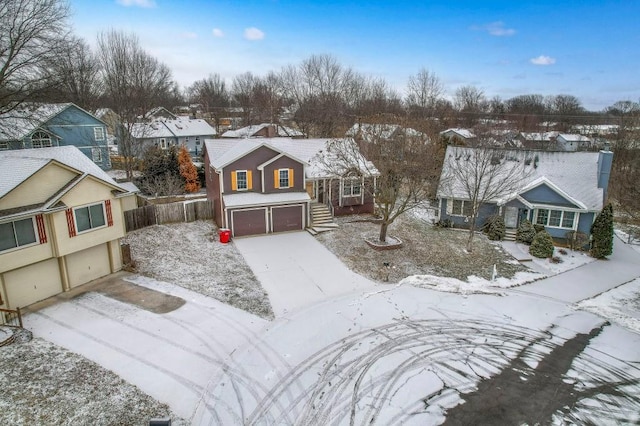 view of front of home with a residential view, concrete driveway, fence, and an attached garage