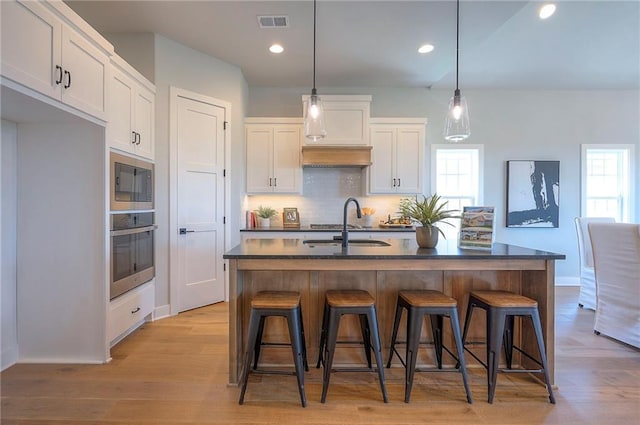 17372 S Kaw St, Olathe, KS 66062 - kitchen featuring oven, dark countertops, a sink, decorative backsplash, and white cabinets