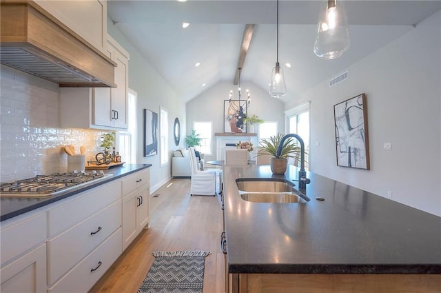 17372 S Kaw St, Olathe, KS 66062 - kitchen with stainless steel gas cooktop, a sink, custom exhaust hood, and dark countertops