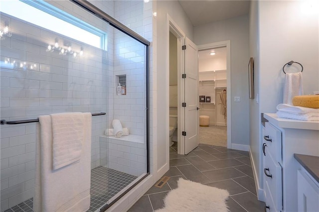 17372 S Kaw St, Olathe, KS 66062 - bathroom with vanity, a walk in closet, a stall shower, and toilet