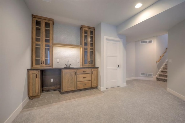 17372 S Kaw St, Olathe, KS 66062 - indoor wet bar featuring light carpet, baseboards, decorative backsplash, stairway, and recessed lighting