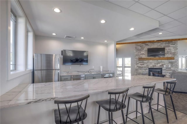 17372 S Kaw St, Olathe, KS 66062 - kitchen with freestanding refrigerator, healthy amount of natural light, light stone countertops, dishwasher, and recessed lighting
