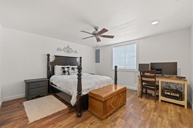 bedroom featuring electric panel, baseboards, and wood finished floors