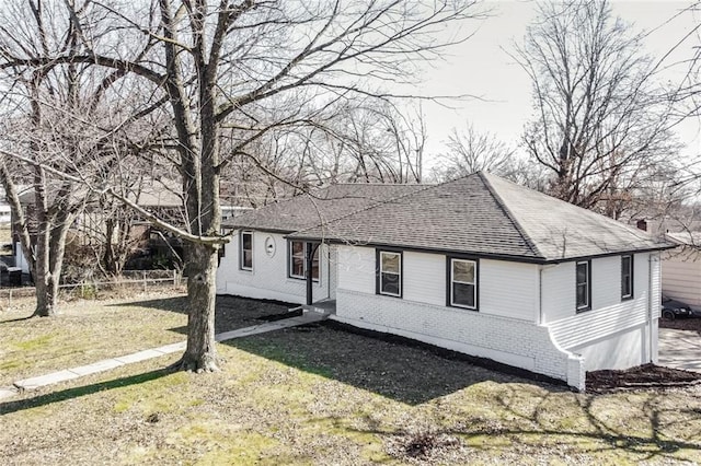 view of front of home featuring brick siding, a front lawn, and a shingled roof