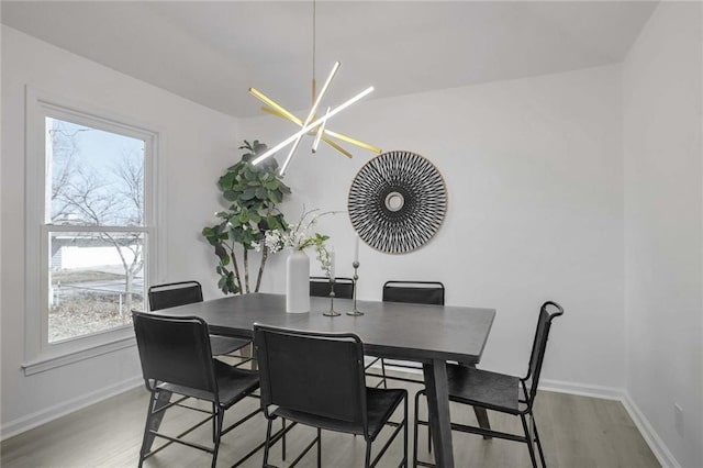 dining room featuring baseboards, an inviting chandelier, and wood finished floors