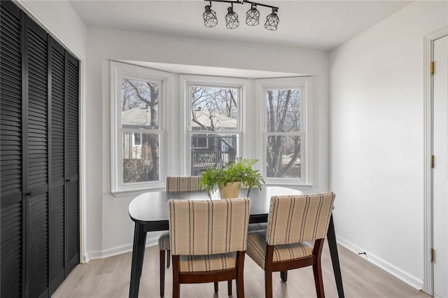 dining room with light wood finished floors and baseboards