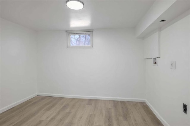 below grade area with light wood-style floors and baseboards