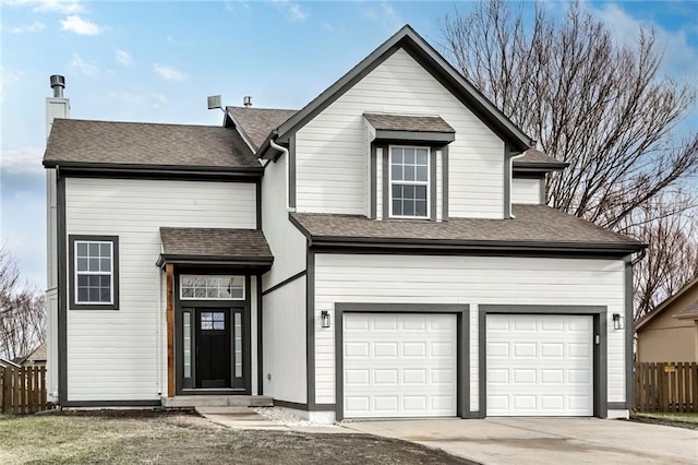 traditional home with a shingled roof, fence, and concrete driveway