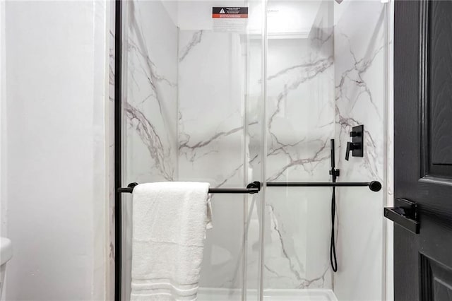 full bath with a marble finish shower