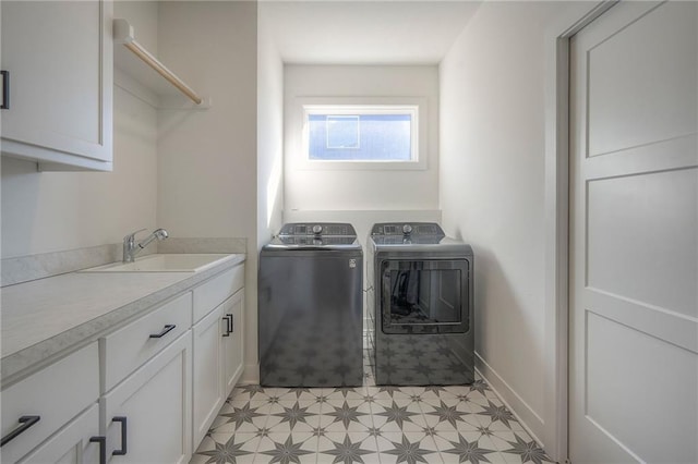 clothes washing area with washing machine and dryer, a sink, baseboards, cabinet space, and light floors