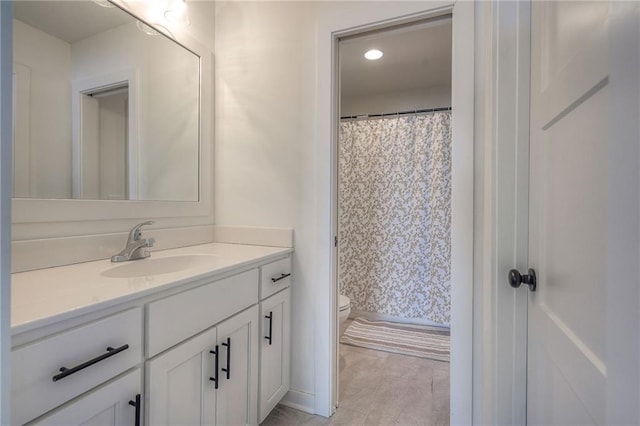 bathroom with toilet, a shower with shower curtain, and vanity