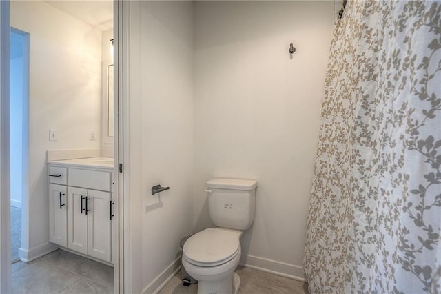 bathroom with curtained shower, vanity, toilet, and baseboards