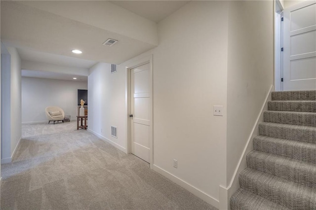 hall featuring baseboards, stairs, and visible vents