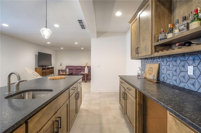 kitchen featuring tasteful backsplash, recessed lighting, visible vents, hanging light fixtures, and a sink