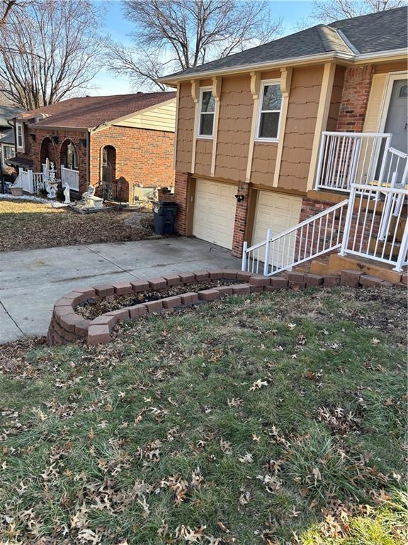 view of side of home featuring a garage, covered porch, concrete driveway, and brick siding