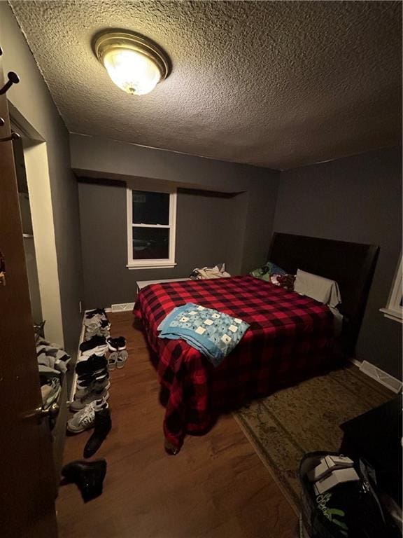 bedroom featuring a textured ceiling and wood finished floors