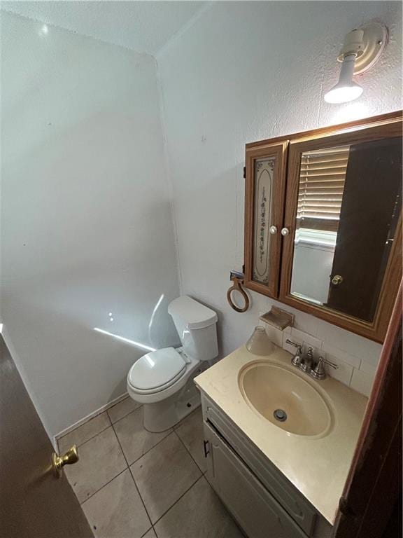 bathroom featuring tile patterned flooring, vanity, and toilet