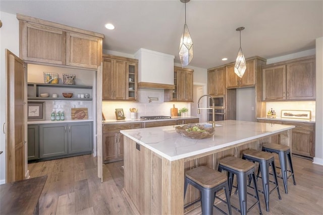12604 W 170th St, Overland Park, KS 66221 - kitchen with stainless steel appliances, light wood-style flooring, decorative backsplash, light stone counters, and brown cabinetry