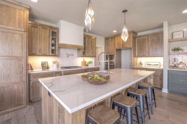 12604 W 170th St, Overland Park, KS 66221 - kitchen with appliances with stainless steel finishes, backsplash, wood finished floors, light stone counters, and brown cabinetry