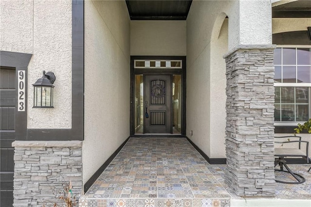 property entrance with stone siding and stucco siding