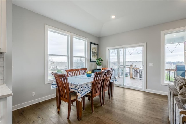 dining room with lofted ceiling, baseboards, and dark wood-style flooring