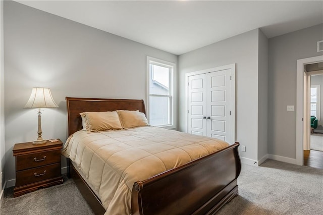 carpeted bedroom featuring visible vents, baseboards, and a closet