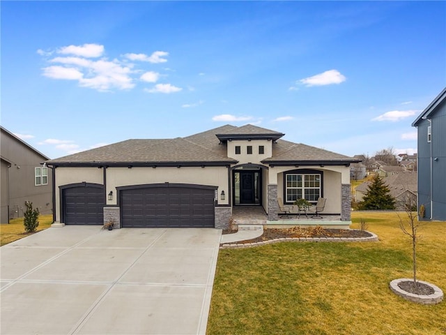 prairie-style home with a garage, concrete driveway, a front lawn, and stucco siding