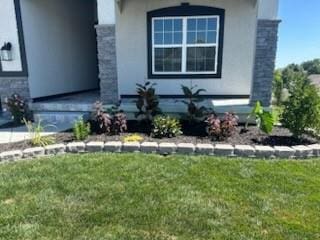 view of home's exterior featuring stone siding, stucco siding, and a yard