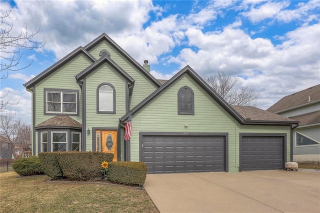 traditional-style home with a garage, a front yard, and driveway