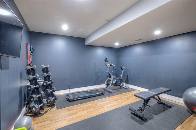 exercise room featuring visible vents, baseboards, wood finished floors, and recessed lighting