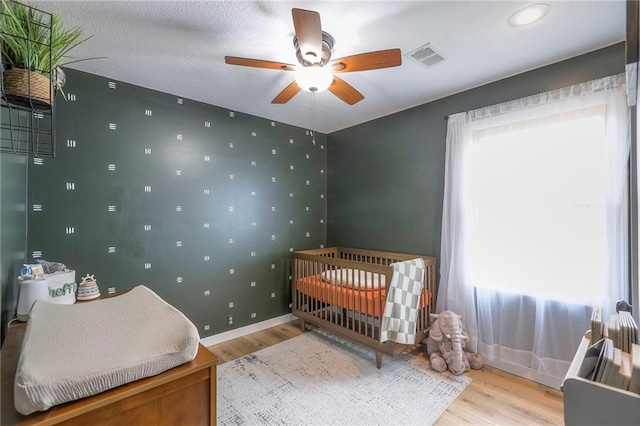 bedroom featuring multiple windows, wood finished floors, visible vents, and baseboards