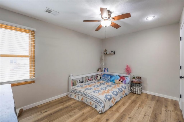 bedroom featuring baseboards, visible vents, and wood finished floors