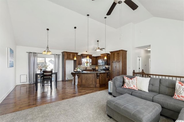 living room featuring dark wood-style floors, lofted ceiling, dark carpet, and ceiling fan