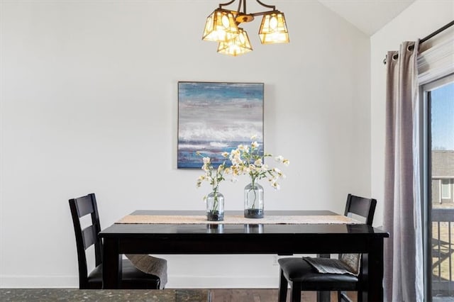 dining space with lofted ceiling, an inviting chandelier, and baseboards